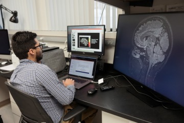Researcher looking at brain imaging scan in the Weinkauf Lab