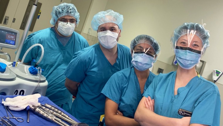 Group of four surgeons in operating room.